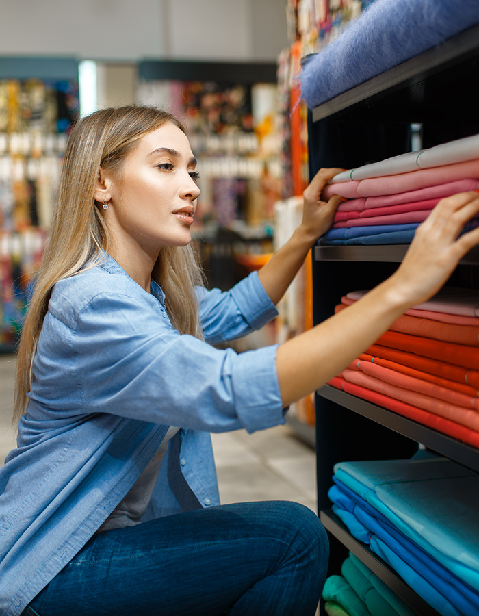 saleswoman measures fabric in textile store Z5W4B3B